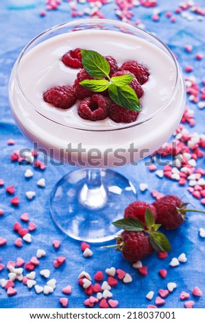raspberry yogurt with fresh berries on a blue background