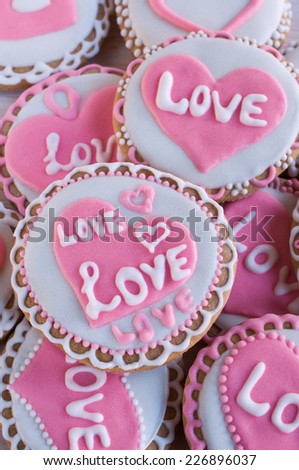background with homemade cookies with frosting in the shape of hearts and the words 