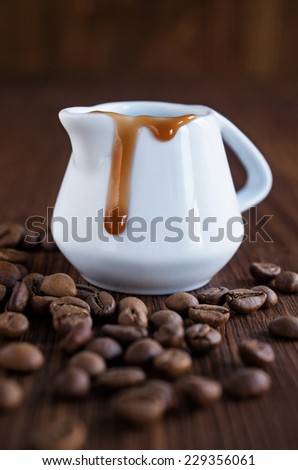 coffee syrup with beans on the wooden background
