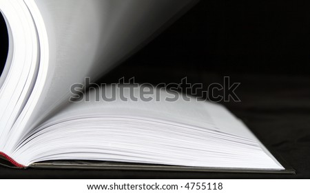 Book with moving sheets on a black background