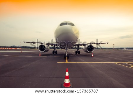 Commercial airplane parking at the airport - front, with traffic cone
