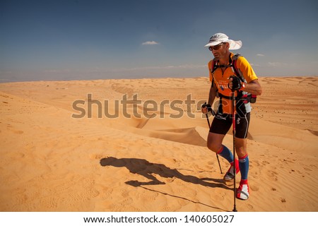 OMAN - DECEMBER 11: Unidentified runner running on dunes on extreme marathon, on December 11, 2011. Raid Oman is one of the most extreme but also one of the most beautiful marathons in the world.