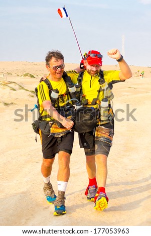 WAHIBA DESERT, OMAN - JANUARY 31: Two unidentified runners arriving to the finish point of one of the hardest extreme endurance desert marathons in the world - Transomania, on January 31, 2014.