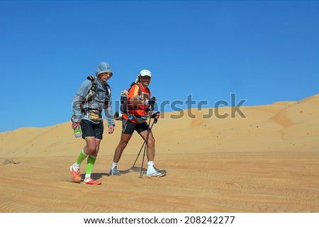 WAHIBA DESERT, OMAN - JANUARY 29: Two unidentified runners running in desert, on January 29, 2014. Desert running is part of the extreme endurance marathon Transomania.