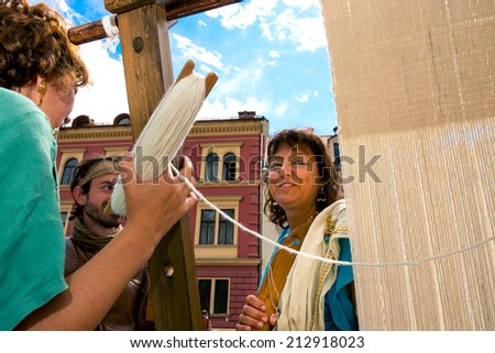 LJUBLJANA, SLOVENIA - AUGUST 24, 2014: Roman camp, life in ancient Rome and unidentified women and man spinning wool, dressed in traditional Roman dresses, in Ljubljana.