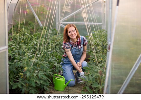 Smiling girl working in greenhouse