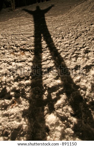 Long and spooky looking shadow of a man on the snow
