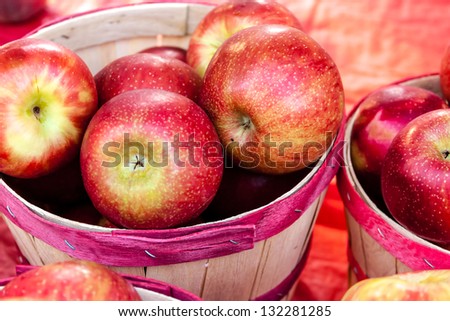 Close up of bushel basket full of fresh organic red apples at local farmers market