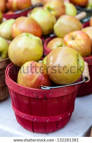 Display of fresh locally grown red apples in colorful bushel baskets on display at local farmers market