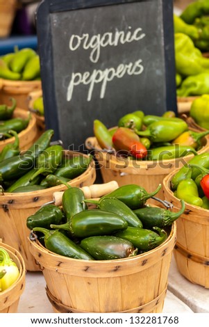 Organic and locally grown fresh jalapeno peppers displayed in brown bushel baskets at local farmers market