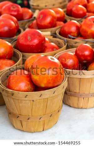 Organically grown baskets full of fresh red tomatoes for sale at local farmer market
