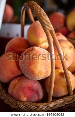 Large basket of fresh yellow peaches for sale in orchard store