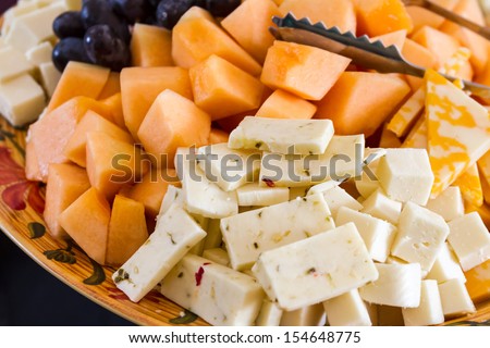 Close up of hors d\'oeuvre platter of assorted cheeses and fruits