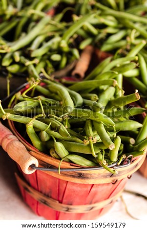 Locally grown organic green beans in colorful baskets for sale at local farmers market
