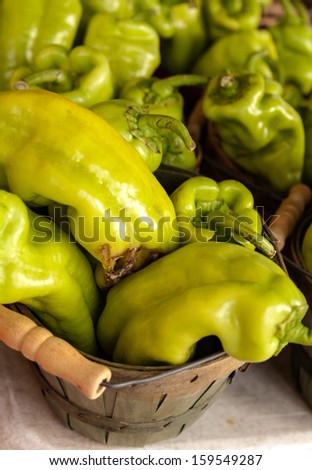 Locally grown hot peppers in small brown baskets for sale at local farmers market