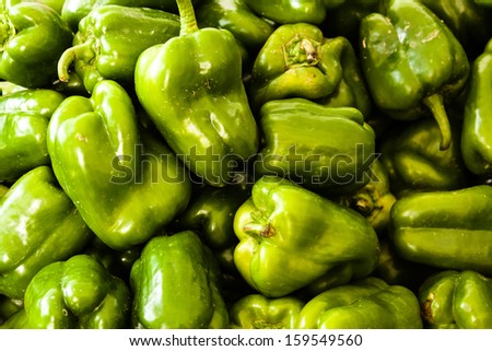 Display of locally grown green bell peppers for sale at local farmers market