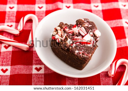 Candy cane fudge in heart shape sitting on festive red and white napkin