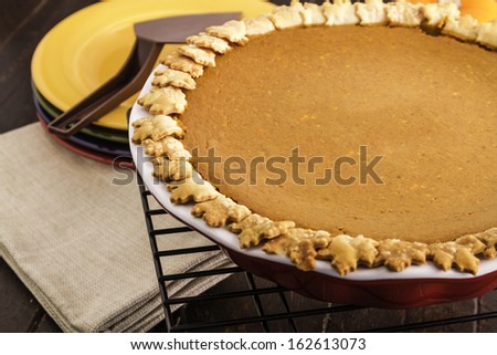 Close up of whole pumpkin pie sitting on wire baking rack