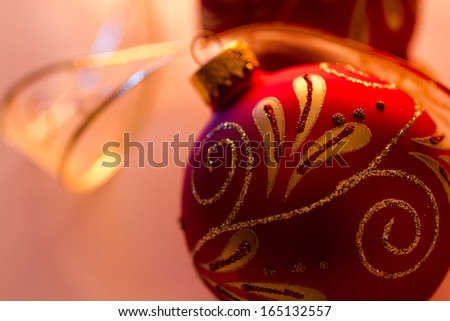 Close up of red and gold glitter Christmas ornaments with gold ribbon