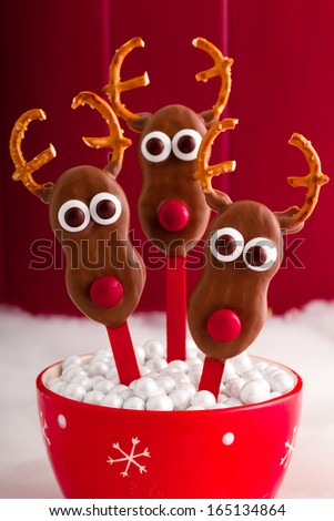 Homemade cookie pop reindeer in red snowflake bowl