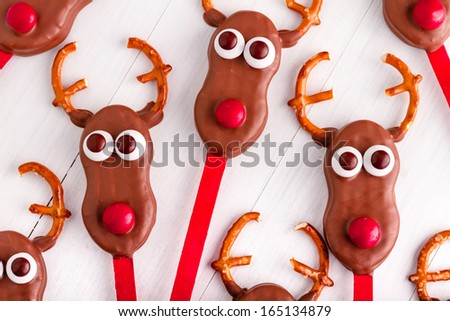 Homemade reindeer cookie pops on white wooden table