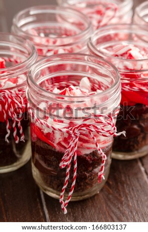 Chocolate peppermint cupcakes in a jar with red and white bakers twine sitting on old brown table