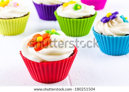 Brightly colored springtime flower chocolate cupcakes on white background