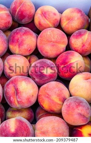 Box full of fresh locally grown peaches for sale at local farmers market