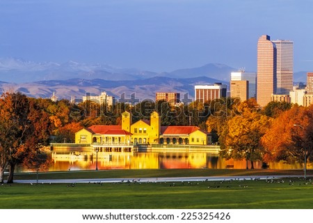 Denver Colorado skyline from City Park with City Park Boathouse and Rocky Mountains in background on autumn morning