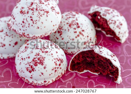 Red velvet cake balls with red sugar sprinkles sitting on red chalk board heart background