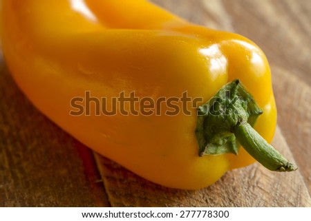 Close up of yellow sweet pepper sitting on wooden table