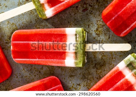 Close up of frozen fresh fruit watermelon and kiwi popsicles sitting on metal baking pan