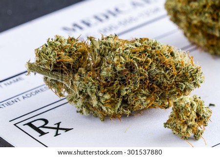 Close up of medical marijuana buds sitting medical prescription pad on black background