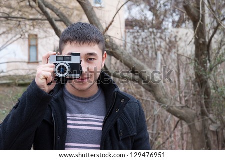 Young photographer with vintage camera on nature