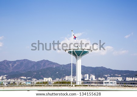 Korean flag in front of air traffic control tower with moutain and blue skies background