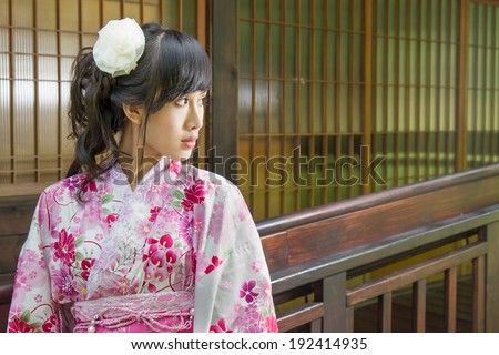 Asian woman wearing kimono by Japanese house