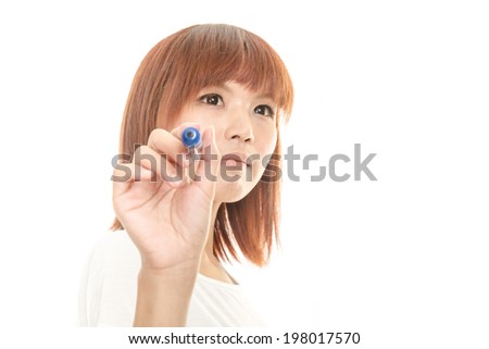 Taiwanese woman writing on futuristic board with blue marker, in deep thought