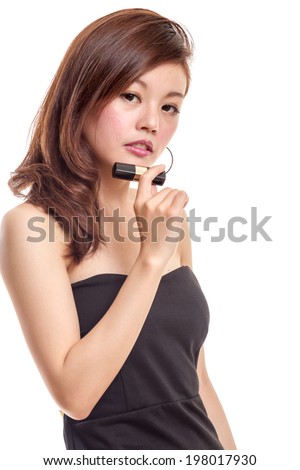 Chinese woman in black dress holding lipstick while putting on makeup