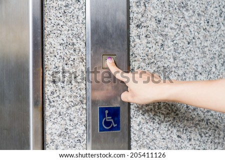 Female hand pressing elevator button