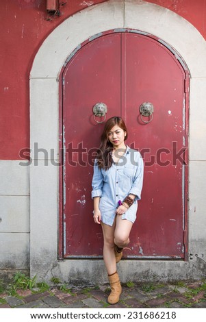 Asian woman in front of traditional Chinese door with ornate lion head knockers