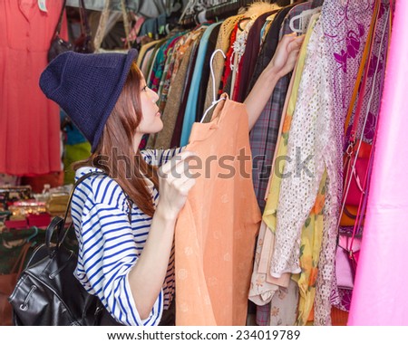 Chinese woman looking through clothing on racks at a street market in Taipei