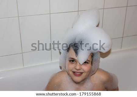 autistic child in a cap of foam soap smiling creative son hat of foam