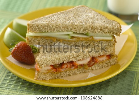 Peanut butter sandwich with apple and strawberries