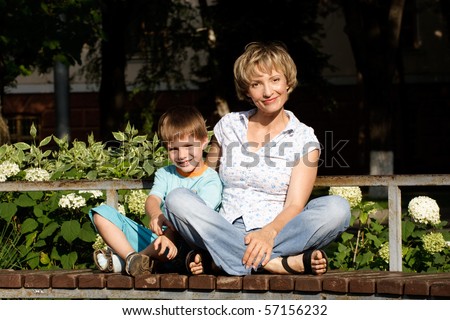 Woman and son sitting on the bench in park