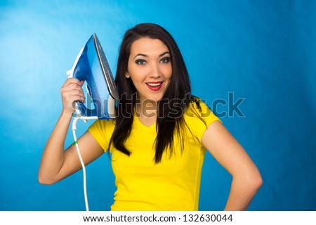 Houseworks, woman with pile of clothes for ironing, on blue background - stock photo