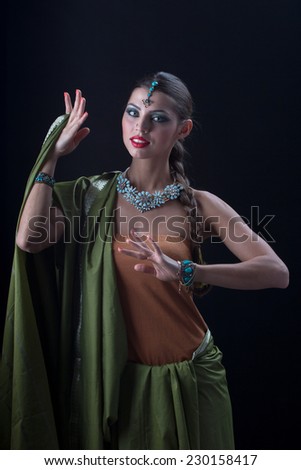 Beautiful Indian girl dancing in national dress on black background