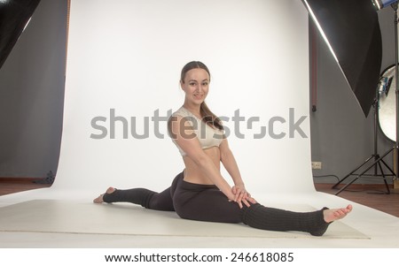Young woman in advanced sitting yoga pose in studio
