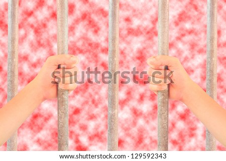 Hand holding grip on the bars of the cage.
