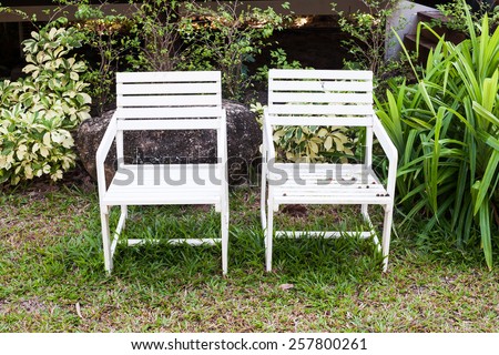 white wooden lawn chairs at the front ( back ) yard.