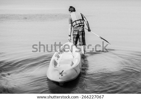 a man drags boat, B&W